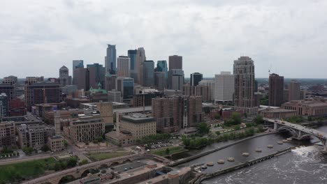 Wide-reverse-pullback-aerial-shot-of-downtown-Minneapolis,-Minnesota-along-the-Mississippi-River