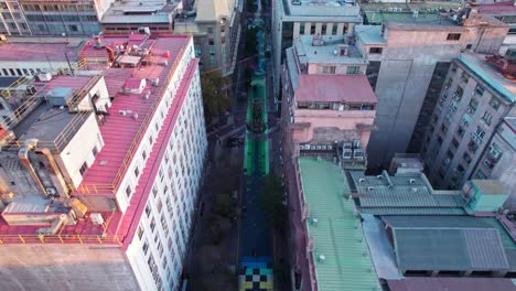 Aerial-view-flying-down-Paseo-Bandera-colourful-urban-street-walkway-art-in-Santiago-city-centre,-Chile