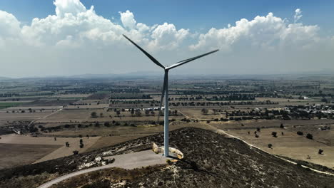 Aerial-view-in-front-of-a-large-wind-turbine-in-Puebla,-Mexico---ascending,-tilt,-drone-shot