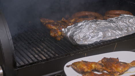 Man-with-plate-takes-BBQ-Chicken-thighs-off-of-smoking-BBQ-pit