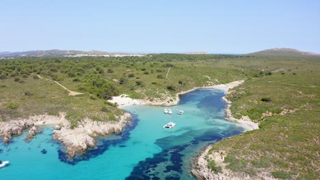 Secluded-cove-along-the-coastline-of-Menorca-with-yachts-anchored-in-the-shallow-waters