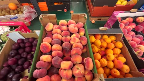A-shelf-with-fruits-and-vegetables-in-a-grocery-store,-peaches-are-lying-in-containers