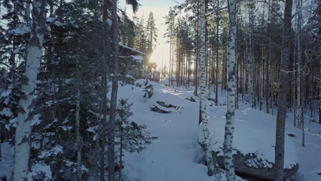 Dolly-View-Nordic-Winter-Cabin-And-Morning-Sunrise-in-cold-snowy-forest,-Nordic-Vacation-Scene