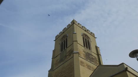 Vögel-Fliegen-Durch-Den-Blauen-Himmel-über-Historischen-Gebäuden-In-Cambridge,-England