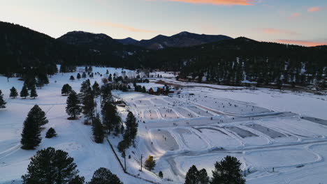 Mid-winter-Colorado-Evergreen-Lake-under-lights-sunset-playing-hockey-and-ice-skating-at-various-rinks-pan-left