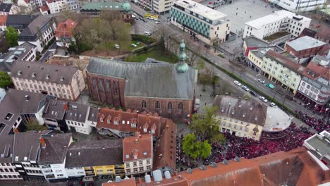 Aerial-rising-up-tilting-down,-FCK-Football-audience-fans-crowd-celebrating-win-at-the-bars-of-old-city-in-Kaiserslautern-Germany