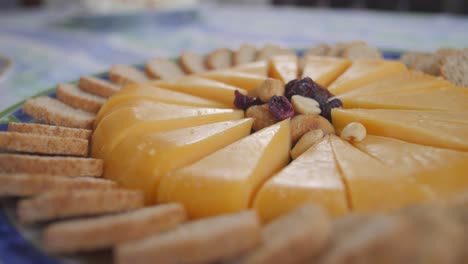 Stücke-Käse-Und-Nüsse-Und-Rosinen-Auf-Einem-Teller-Auf-Dem-Tisch