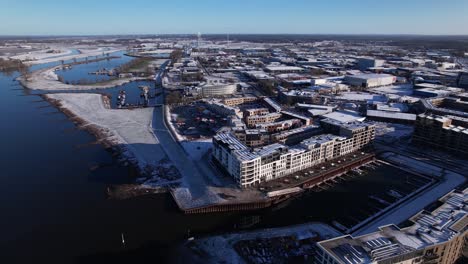 Noorderhaven-neighbourhood-along-river-IJssel-aerial-with-contemporary-new-luxury-apartment-building-in-bright-snow-cityscape-and-recreational-port-in-the-foreground