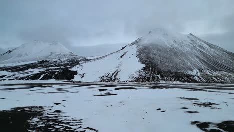 Snowfall-in-Volcanic-Landscape,-Cinematic-Aerial-on-an-Overcast-Day