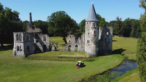 Castle-ruin,-river,-tractor-cutting-grass