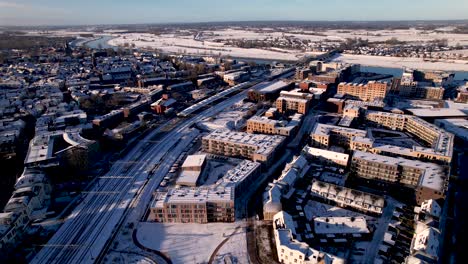 Aerial-descending-approach-of-exterior-facade-residential-housing-at-the-Ettegerpark-during-sunrise-after-a-snowstorm-with-inclusive-park-covered-in-snow-Dutch-real-estate-investment-urban-development