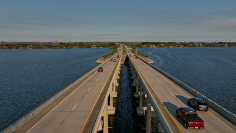 Merritt-Island-Florida-Aerial-v8-cinematic-drone-flyover-Indian-river,-flying-straight-above-Pineda-Causeway-capturing-commuters-traffics-on-the-road-bridge---Shot-with-Mavic-3-Cine---March-2022