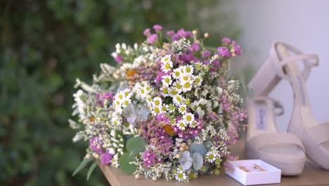 Extreme-close-up-shot-of-Wildflowers-bouquet-with-bride-accessories,-Camera-floating