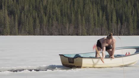 Man-In-Rowing-Boat-Breaking-Ice-Using-Axe-In-A-Frosted-Lake-During-Winter