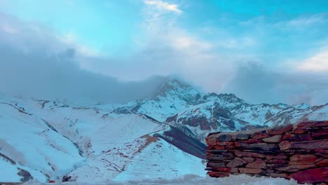 Blick-Auf-Die-Spitze-Des-Berges-Kazbegi-Hinter-Einer-Ziegelmauer