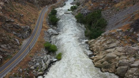 Schneller-Lufttransport-Den-Kern-River-Auf-Dem-Highway-178-Vom-Lake-Isabella-Dam-In-Bakersfield-Während-Einer-Wütenden-Überschwemmung-Mit-Schnellem,-Turbulentem-Wasser,-Das-Hart-Rauscht-Und-Bäume-Bedeckt