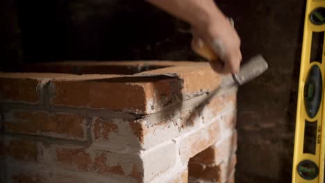 Low-Closeup-of-Mexican-Man-Putting-Together-Small-Brick-Stove
