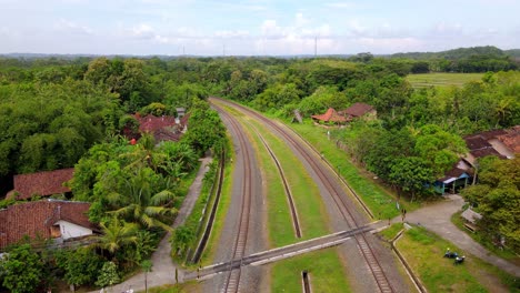 Vista-Aérea-Del-Ferrocarril-En-Medio-Del-Campo-Indonesio---Imágenes-De-Drones-Del-Paisaje-Rural