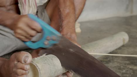 craftsman-indian-male-cutting-a-bamboo-stick-making-artisan-product