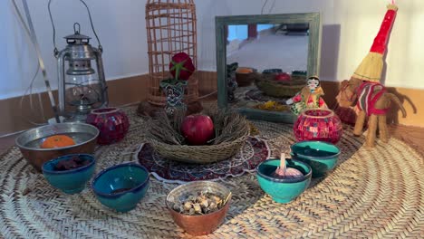 Sonnenschatten-Auf-Einer-Traditionellen-Rituellen-Zeremonie,-Einem-Haftsin-Tisch,-Einem-Holzkorb-Aus-Korbgeflecht,-Einem-Spiegel,-Einer-Puppe,-Einer-Sumach-Orange-Wasserschale,-Einer-Religiösen-Laterne,-Einer-Kerze,-Handgefertigtem-Kunsthandwerk-Der-Einheimischen,-Traditionellen-Fertigkeiten,-Kunst-Im-Iran