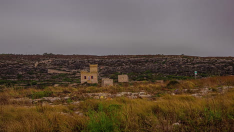 Aerial-drone-shot-of-old-historic-building-surrounded-by-desert-vegetation-on-a-cloudy-day-in-timelapse