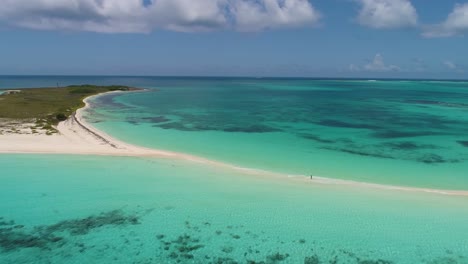drone-shot-along-sandbank-cayo-de-agua-cloudy-day,-pan-right,-Cayo-de-Agua-island-Los-Roques