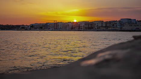 Die-Untergehende-Sonne-Fällt-Unter-Eigentumswohnungshotels-Zur-Goldenen-Stunde.-Sonnenuntergang-Von-Gzira,-Malta,-Zeitraffer