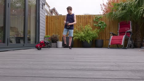 Young-boy-at-home-outdoors-in-the-garden-playing-with-his-RC-Car,-Truck,-4-x-4