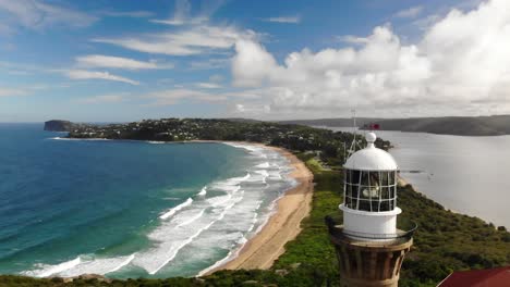 Palm-beach-lighthouse-drone-view,-stunning-aerial-close-up-of-Palm-Beach,-Australia-with-its-panoramic-coastline,-crystal-clear-waters,-and-iconic-lighthouse