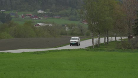White-Vehicle-Driving-On-The-Street-Through-Fields-In-Indre-Fosen,-Norway