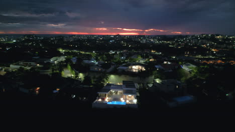 Aerial-rise-at-night-over-community-in-Noumea,-capital-city-of-New-Caledonia