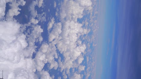 Vertikaler-Blick-über-Wunderschöne,-Flauschige-Wolken-Vor-Blauem-Himmel
