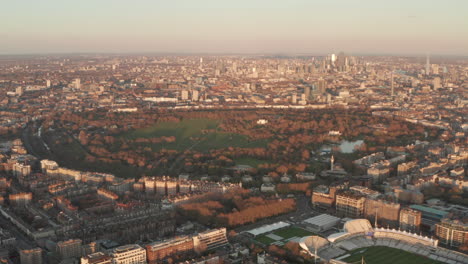 Rising-circling-aerial-shot-of-Regents-park-with-London-skyline-in-the-background-at-sunset