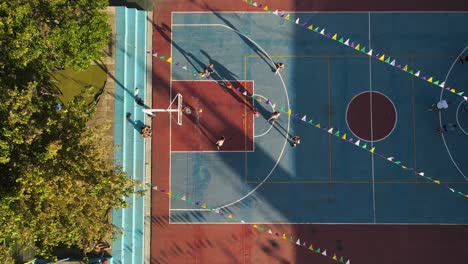 Luftaufnahme-Von-Oben-Nach-Unten-Eines-Teenagers,-Der-Während-Der-Goldenen-Stunde-Basketball-Auf-Einem-Amateurfeld-In-Buenos-Aires-übt