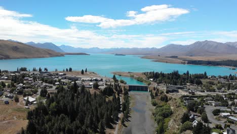 Lake-Tekapo-Village-and-Same-Name-Lake,-Aerial-View-of-Coast-and-Control-Gates