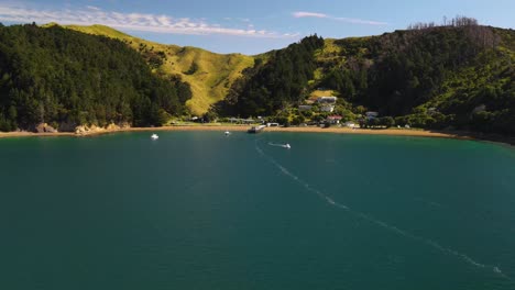 Drone-fly-to-picturesque-bay-with-beach-and-small-settlement-near-French-Pass,-New-Zealand