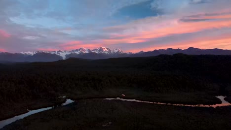 Hermosa-Vista-Del-Paisaje-Natural-De-Nueva-Zelanda,-Alta-Cordillera-En-El-Horizonte-Durante-El-Colorido-Amanecer---Panorámica-Aérea