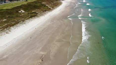 Papamoa-Beach-aerial-reveal,Mount-Maunganui-on-horizon,-sunny-day-at-New-Zealand-coastline