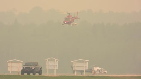 An-emergency-helicopter-takes-off-in-a-dense-smoke-of-a-forest-fire