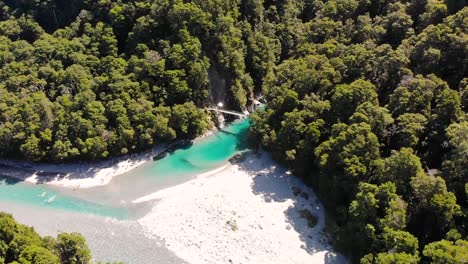 Vista-Panorámica-De-La-Pista-De-Las-Piscinas-Azules-En-La-Costa-Oeste,-Nueva-Zelanda---Agua-Azul-Del-Río-Con-Arena-Blanca-Y-Un-Exuberante-Bosque-De-Hayas-Verdes---Drone-Aéreo