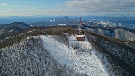 Aerial-4K-drone-footage-of-a-TV-and-radio-communication-center-on-the-top-of-the-mountain-in-the-winter-time