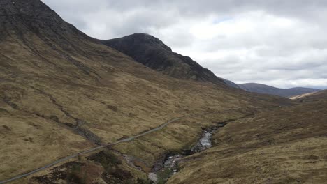 Panoramic-view-of-mountains-with-rocky-slopes-and-dry-vegetation-in-Scotland