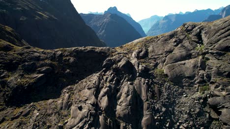 Gertrude-Saddle-lookout-aerial-reveal-of-Milford-Sound-fjord-on-horizon