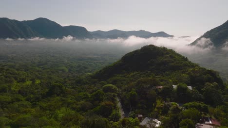 Drone-Flies-Above-Countryside-Mountains-Landscape-In-Panama-During-Sunrise,-foggy-morning-with-clouds,-El-Valle-De-Anton-Crater