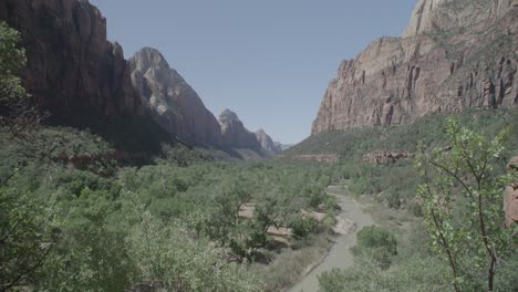 a-mountain-range-with-a-river-flowing-through-the-canyons-at-zion-national-park