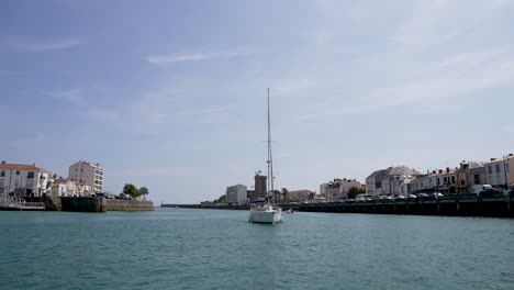 Tall-mast-sailboat-yacht-entering-the-port-from-the-Atlantic-ocean-at-Les-Sables-D'olonne-Western-France,-View-from-boat
