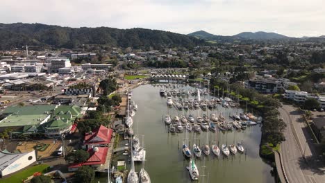 Nice-aerial-pull-back-of-Whangarei-city,-Victoria-Canopy-Bridge,-Town-Basin-Marina-Village,-Museum-and-Whangarei-Marina-on-riverfront-of-Hatea-river