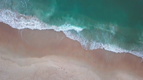 Top-Down-Aerial-Shot-of-People-on-Beach-and-Waves-Crashing-Ashore-in-Atlantic-Ocean