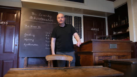Wide-shot-of-a-male-teaching-in-old-victorian-school-classroom