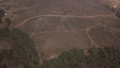 View-from-a-drone-flying-in-circles-showing-a-mountain-with-two-roads-close-to-a-forest-in-mexico